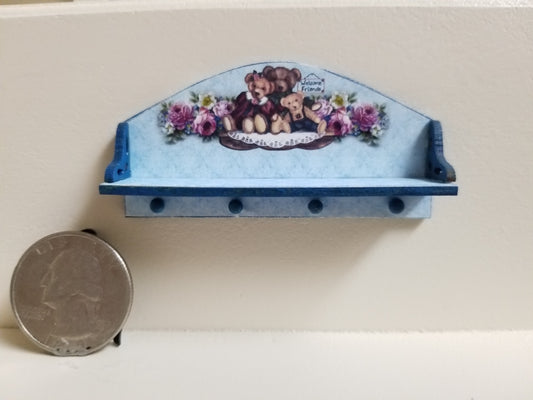 Miniature wooden peg shelf with teddy bear theme, blue with purple accents